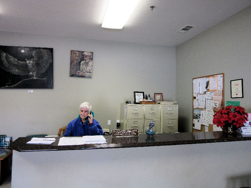 A volunteer welcoming visitors at the Manna House front desk